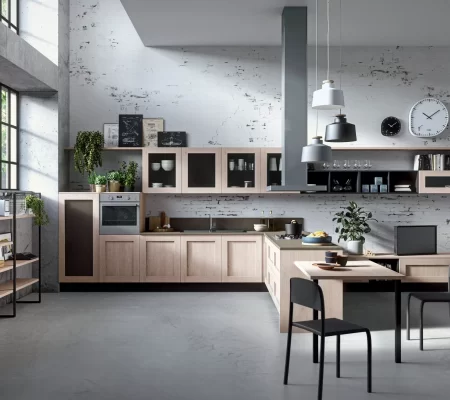 Cucina open space in stile moderno con finiture in legno chiaro e piano snack